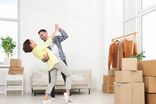 Happy couple dancing in new apartment. Moving day - 写真・画像