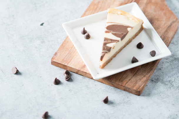 Chocolate swirl cheesecake slice on square plate  - Foto, imagen