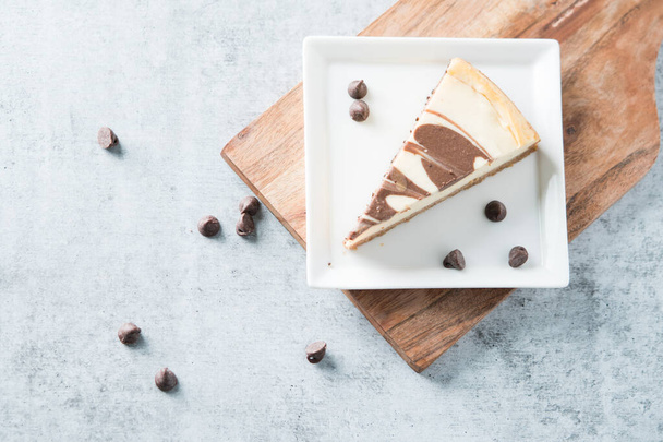 Chocolate swirl cheesecake slice on square plate  - Photo, Image