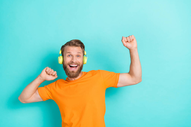 Photo of hooray beard guy listen music dance wear headphones orange t-shirt isolated on teal color backgroiund. - Foto, immagini