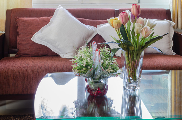 vaso de vidro de flor na mesa de vidro com sofá de madeira
 - Foto, Imagem