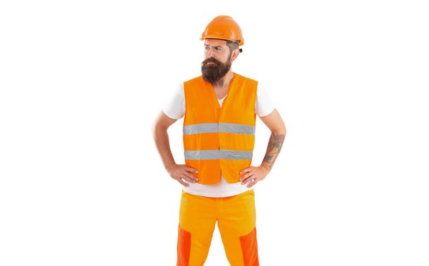 sad builder man in uniform. bearded builder in orange vest. studio shot of builder wearing helmet. builder isolated on white background. - Photo, Image