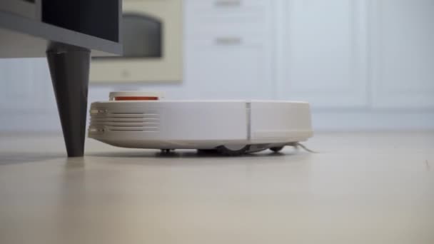 robot vacuum cleaner cleans around the table, smart sensors. High quality 4k footage - Footage, Video