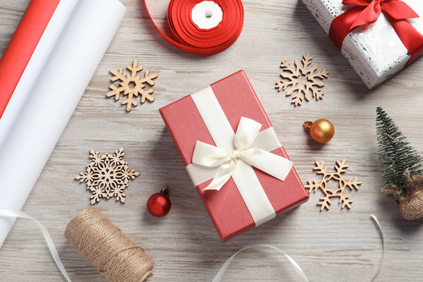Flat lay composition with beautiful Christmas gift boxes and wrapping paper on white wooden table - Foto, Bild