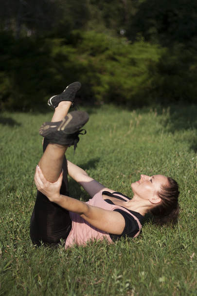 Young woman doing fitness outdoors - 写真・画像