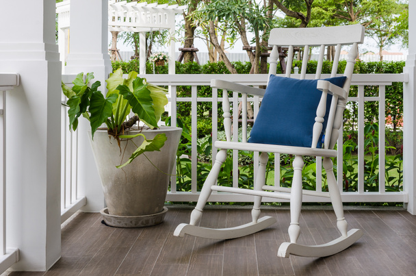 cadeira de balanço de madeira branca no alpendre da frente em casa
 - Foto, Imagem