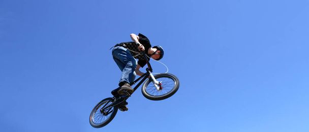 bmx acrobat tijdens het springen en de lucht - Foto, afbeelding