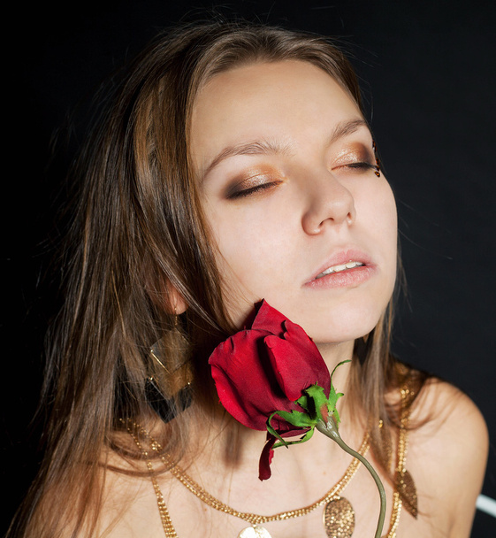 Closeup portrait of beautiful young girl with rose - 写真・画像