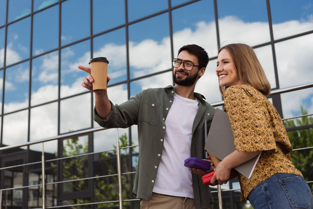 Lächelnde Geschäftsleute mit Lunchpaketen und Kaffee zum Wegschauen auf der Straße  - Foto, Bild