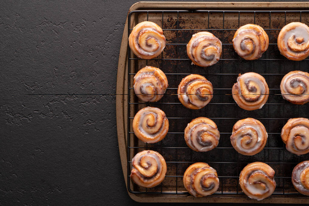 Homemade baked cinnamon rolls baked in a cookie sheet with icing. - Photo, Image
