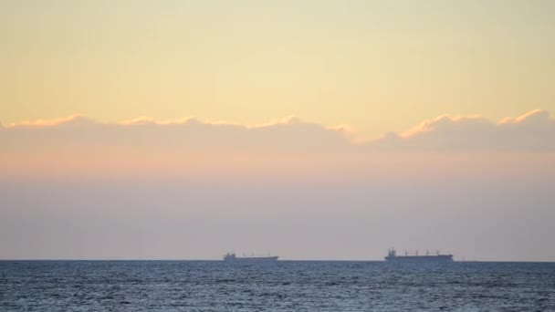 Zaman ayarlı. Denizdeki ufuk çizgisinde tanker tankerlerinin silueti ve gün batımında sarı mavi gökyüzünde hızlı hareket eden bulutlar. Deniz manzarası, deniz manzarası. Ulaşım. Doğal arkaplan - Video, Çekim