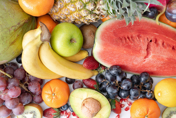 Színes egzotikus gyümölcsök, narancs és görögdinnye, kivi és banán, szőlő és eper fehér alapon. - Fotó, kép