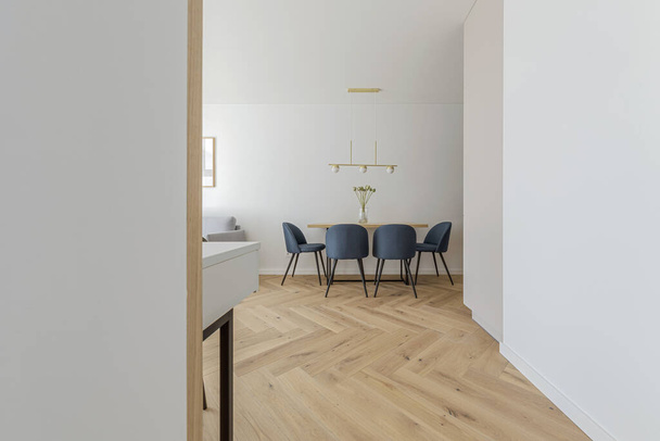 Modern minimalist kitchen and dining room interior design  with wooden furniture, oak floor. blue chairs.  Aesthetic simple interior design concept. - Foto, Bild
