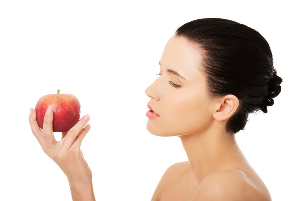 Portrait of bare brunette holding red apple - Photo, Image
