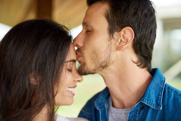 I baci sulla fronte sono sempre i migliori. una giovane coppia affettuosa che trascorre del tempo insieme a casa - Foto, immagini