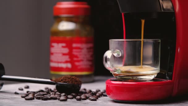 Warme koffie stroomt in een kopje met een espressomachine, close-up. Moderne espressomachine met gemalen koffiemolen in een lepel en koffiebonen gemorst rond op houten tafel. - Video
