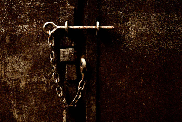 serrure métallique rouillée sur une chaîne sur une vieille porte - Photo, image