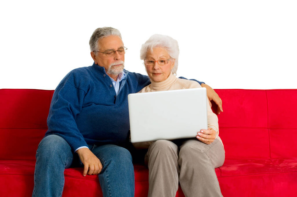 "літня пара на дивані за допомогою ноутбука
" - Фото, зображення
