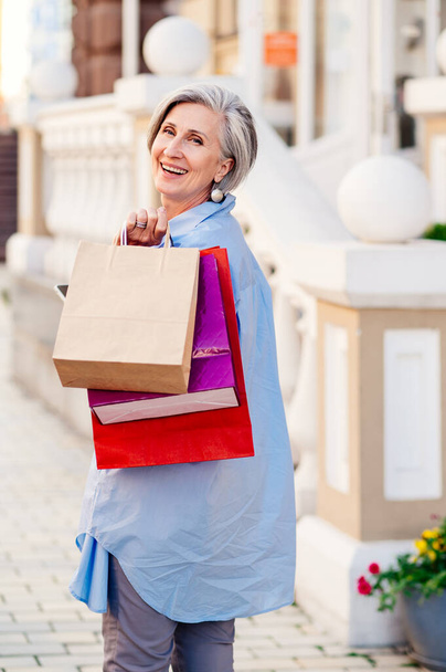 Beautiful and happy senior adult woman shopping in the city - Stylish fashionable old mature people shopping in clothing store - Foto, Bild