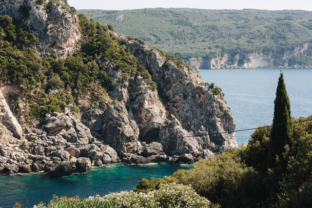 Korfu, Řecko. Krásná krajina s výhledem na obrovské hory a šedé skály v modré vodě pokryté zelenými stromy. - Fotografie, Obrázek