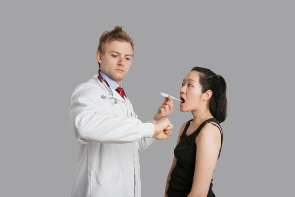 Médico verificando a temperatura do paciente feminino
 - Foto, Imagem