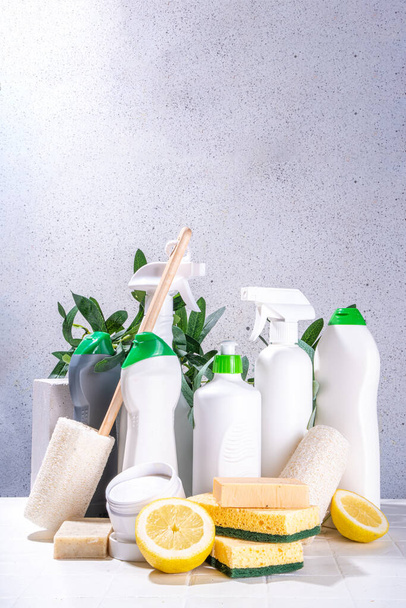 環境に優しい有機洗浄の概念。環境に優しいクリーナー用品-エコブラシ、ツールスポンジ、自然洗浄製品、ソーダ、石鹸、レモン、酢、白い背景に緑の葉を持つボトル - 写真・画像