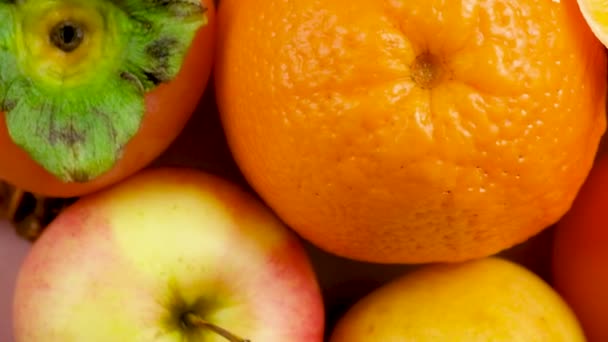Плоды оранжевого и желтого цветов - яблоки, хурма, груши и апельсины, вид сверху. - Кадры, видео