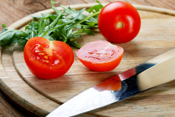 Tomatoes salad a knife on a chopping board - Photo, image