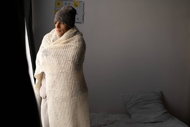 Unwell man renter in blanket sit in cold bedroom.People suffer from lack of heat indoor. Unhealthy young man struggle from chill freeze at home. No heating concept. - Foto, afbeelding