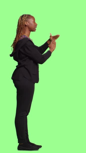 Vertical video: Full body of model showing t shape symbol on greenscreen backdrop, showing break or pause gesture with arms. Standing on green screen background with timeout negative symbol. - Footage, Video