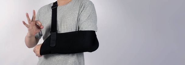 Broken arm. Arm Sling therapy support and covered around elbow first knuckle broken arm. Post Operative Care. Fractures of humerus radius ulna scapula. Arm Sling after accident. Isolated background. - Photo, Image