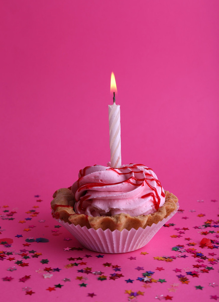 Birthday cup cake with candle and colorful stars on pink background - Фото, зображення