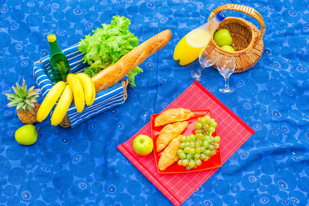 Picknickmand met fruit, brood en witte wijn fles - Foto, afbeelding