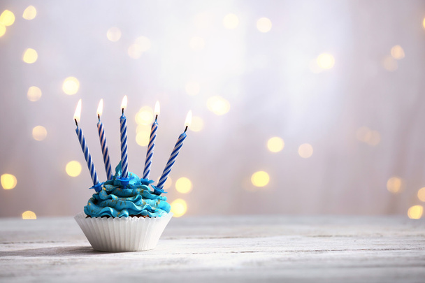 Delicious birthday cupcake on table on light background - Photo, image