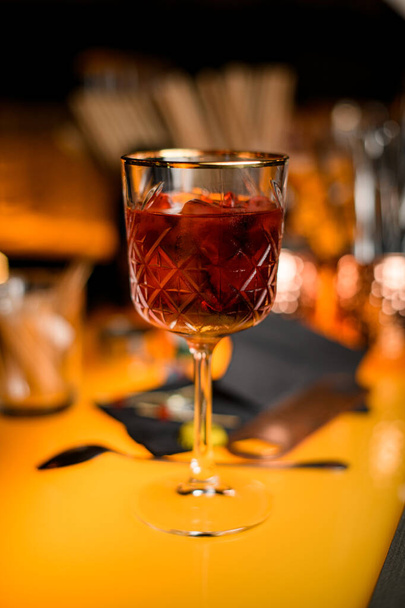 close-up view of beautiful crystal goblet with red alcoholic drink on bar counter with blurry restaurant background scene - Φωτογραφία, εικόνα