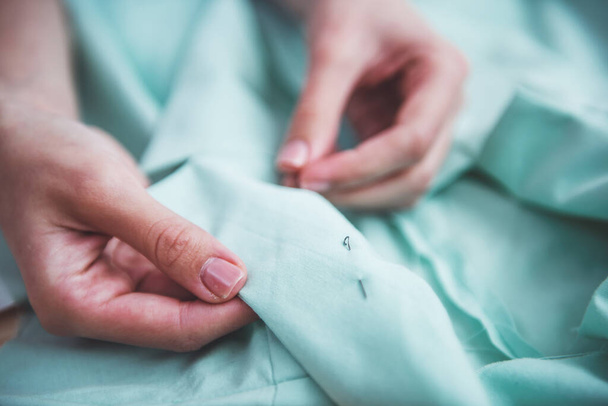 Young designer is sewing while working in dressmaking studio, close-up - Fotoğraf, Görsel