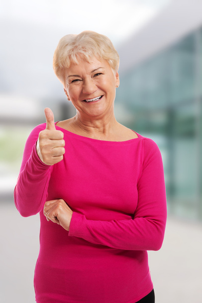 Old woman wearing pink shirt, showing OK. - Фото, зображення