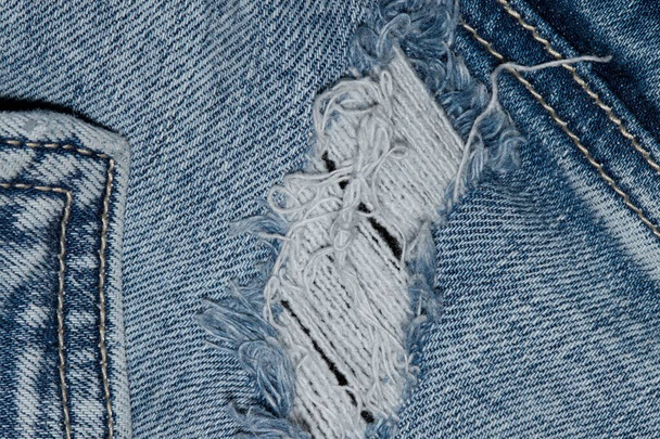 Gescheurde blauwe denim kleding met pocket naden en stiksels. Platte lay-out jeans geïsoleerde sectie. - Foto, afbeelding
