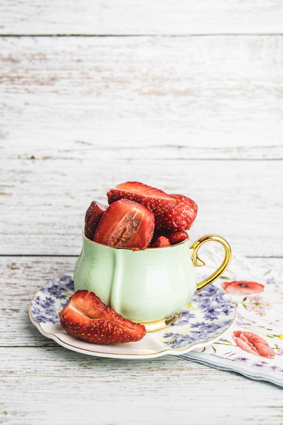 Retro, vintage cup full with strawberries on the table - Foto, imagen