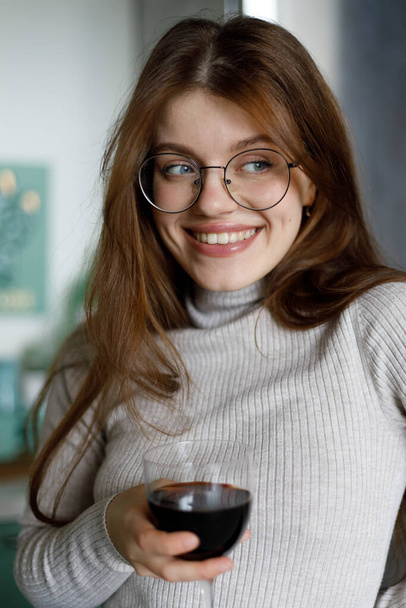 Portrait of an attractive woman with a glass of red wine in her hand. Enjoy alcohol at your leisure. - Photo, Image