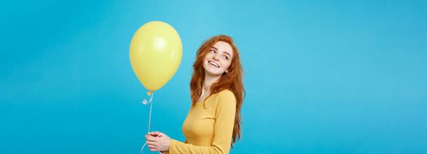 Close up Retrato feliz jovem bonita atraente menina ruiva sorrindo com balão de festa colorido. Fundo azul pastel
. - Foto, Imagem