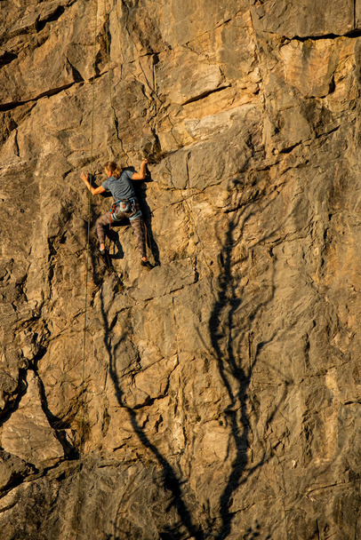 ένας αναρριχητής σκαρφαλώνει σε έναν απότομο βράχο  - Φωτογραφία, εικόνα