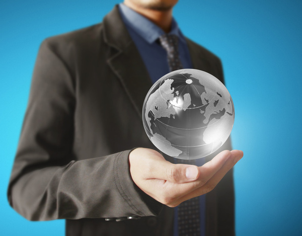 Businessman holding a glowing earth globe - Photo, Image