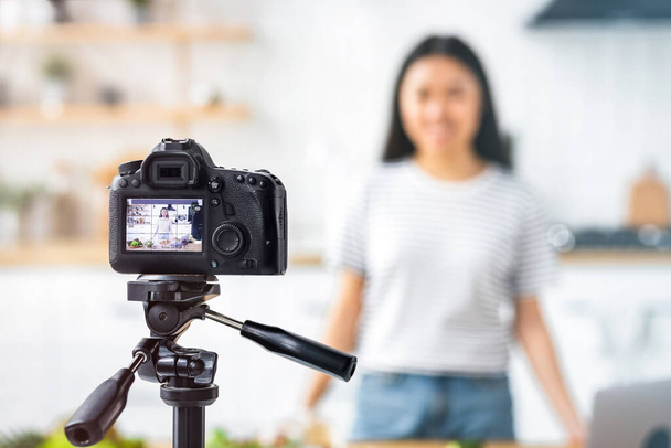 Shot of a young Asian woman nutritionist recording a video content on camera for her vlog standing in the home kitchen, healthy food concept. Live Streaming, broadcast - Valokuva, kuva