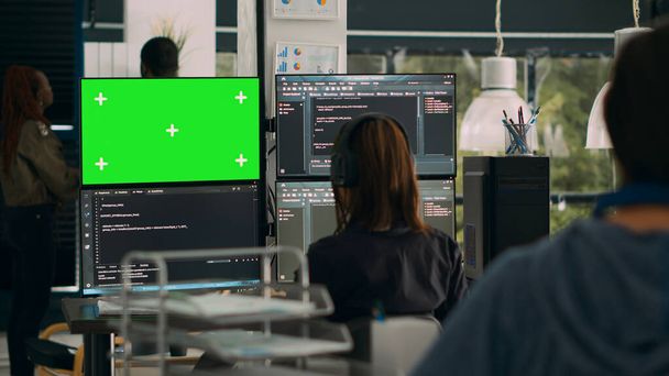 Жінка-програмістка дивиться на зелений екран і код на вікні терміналу, працює з хроматичним дисплеєм і html скриптом в офісі. Використання ізольованого макетного копіювання для розробки програмного забезпечення. Постріл на тринозі
. - Фото, зображення