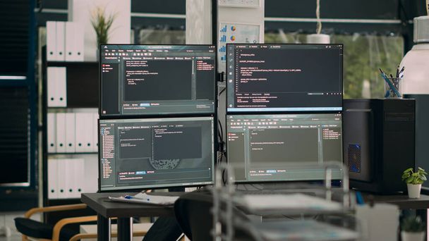 Monitores que muestran el código de análisis en el escritorio vacío de la oficina de la agencia con computadoras que compilan algoritmos de datos. Servidores de inteligencia artificial cloud computing con script html en ventana temrinal. - Foto, imagen