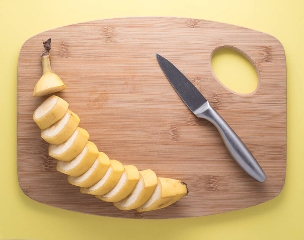 Sliced Banana with knife and cutting board - Фото, изображение