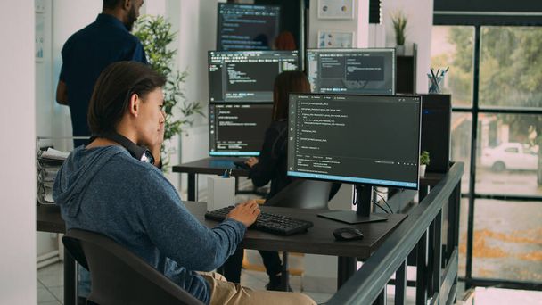 Asiatischer Softwareingenieur arbeitet an einem Sicherheitsprogramm mit Servercode und tippt Systeminformationen auf den Computerbildschirm. Datenbank-Programmierer schreiben Code mit Algorithmen, es Sprache. - Foto, Bild