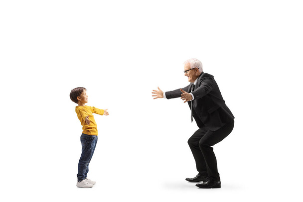Vollständige Profilaufnahme eines Jungen, der einen Geschäftsmann trifft, isoliert auf weißem Hintergrund - Foto, Bild