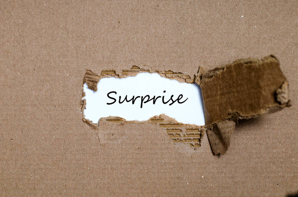das Wort Überraschung erscheint hinter zerrissenem Papier - Foto, Bild